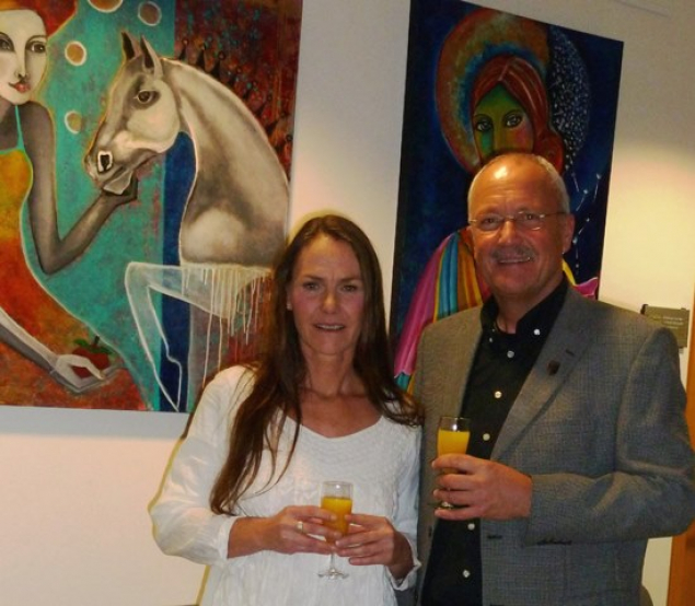 Die Künsterlin Janett Rotter mit Bürgermeister Manfred Helfrich vor zwei ihrer farbenfrohen Werke im Rathaus Poppenhausen