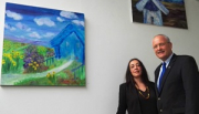 Die Künsterin Antonia Cantalejo u. Bürgermeister Manfred Helfrich vor zwei der Bilder im Rathaus-Foyer, die den Titel tragen „Das blaue Hau“ und „Die Mühle“.