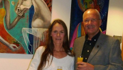 Die Künsterlin Janett Rotter mit Bürgermeister Manfred Helfrich vor zwei ihrer farbenfrohen Werke im Rathaus Poppenhausen