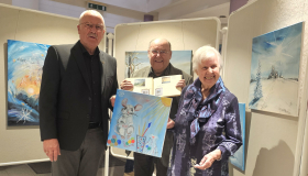 Ulla Hucklenbruch (re.) mit Ihrem Lebenspartner Dieter Sippel (Mitte) und Bürgermeister Manfred Helfrich bei der Eröffnung der Ausstellung im Rathaus-Foyer.