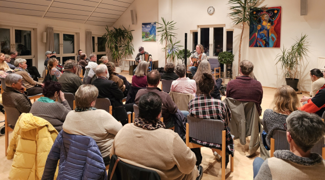 Foto: Gemeinde Ein Blick in den Rathaus-Saal mit Tommy Wild und Addi Haas mit dem lauschenden Publikum.